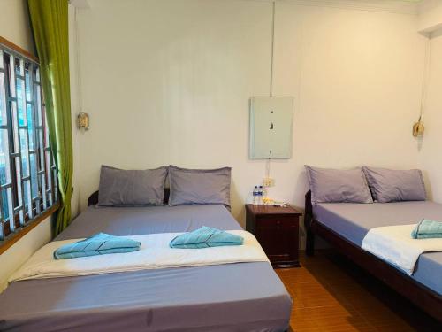 een slaapkamer met twee bedden, een tafel en een raam bij Easy Home Koh Rong in Kaôh Rŭng (3)