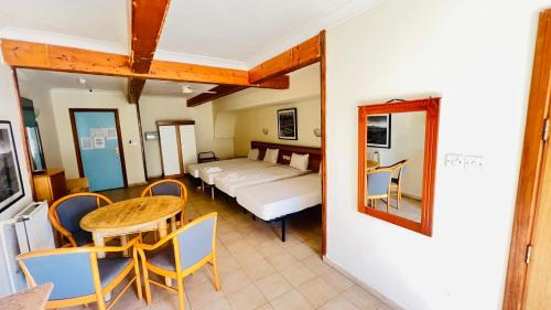 a room with a bed and a table and chairs at Quadruple Room 3629 in St. Paul's Bay