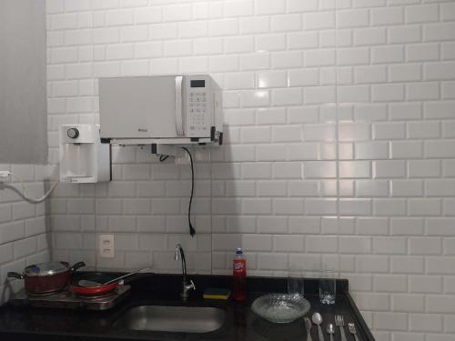 a kitchen counter with a sink and a microwave at KITNET ELVIS PRESLEY - Largo do Machado in Rio de Janeiro