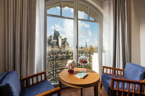 a room with a table and chairs and a large window at Mandarin Oriental Lutetia, Paris in Paris
