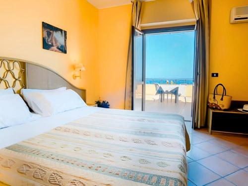 a bedroom with a bed with a view of the ocean at Aura Club Porto Rhoca in Squillace