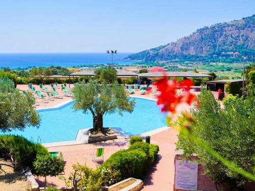 a view of a swimming pool with chairs and the ocean at Aura Club Porto Rhoca in Squillace