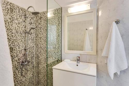 a bathroom with a sink and a shower with a mirror at Villa Aggeliki by Villa Plus in Pírgos Psilonérou