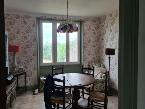 une salle à manger avec une table et des chaises et une fenêtre dans l'établissement Maison Huitlala, à Lavaufranche