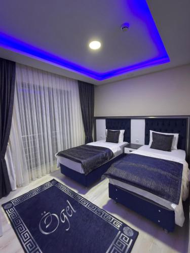 two beds in a room with a blue ceiling at Ögel Apart Otel in Sarıkamıs