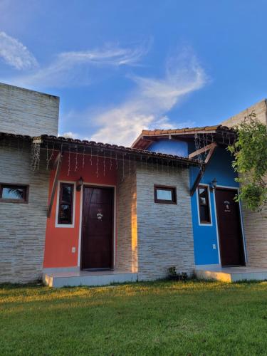 a house with colorful paint on the side of it at Pousada Jeito Bom de Viver in Caraíva