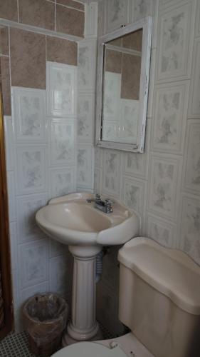 a bathroom with a sink and a toilet and a mirror at Jungle Palace hostal santaella in Puerto Escondido