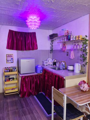een keuken met een tafel en een paars plafond bij Ciel's Haven Free Breakfast in Binangonan