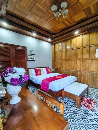 a bedroom with a bed and a table with flowers at Xumi Motel in Hanoi
