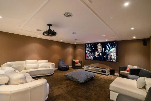 een woonkamer met witte meubels en een flatscreen-tv bij Elyra Cascais in Alcabideche