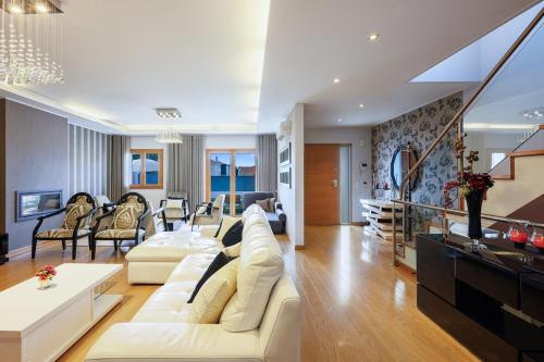een woonkamer met een witte bank en stoelen bij Elyra Cascais in Alcabideche