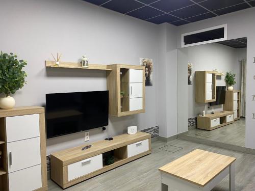 ein Wohnzimmer mit einem Flachbildfernseher an der Wand in der Unterkunft Miamar in Sevilla