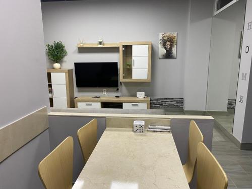ein Esszimmer mit Tisch und Fernseher in der Unterkunft Miamar in Sevilla