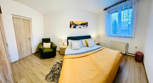 una camera da letto con un letto grande e una sedia di Šumava ski apartment under Zadov 70m2 a Stachy