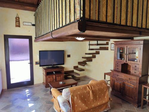 een woonkamer met een bank, een tv en een trap bij La Casa di Ori in Castel SantʼElia