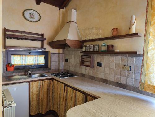 een keuken met een spoelbak en een fornuis bij La Casa di Ori in Castel SantʼElia