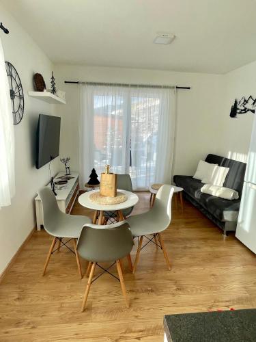 a living room with a table and chairs and a couch at Domeček Jasná in Jeseník