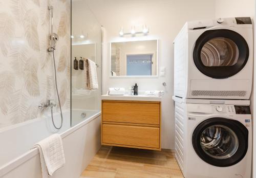 een badkamer met een wasmachine, een wastafel en een wasmachine bij ApartamentyGdansk EU - ŻURAWIE I in Gdańsk