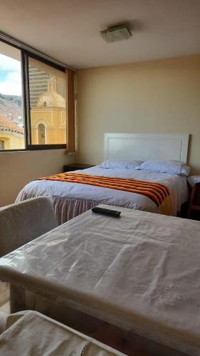 a hotel room with two beds and a window at Plaza murillo in La Paz