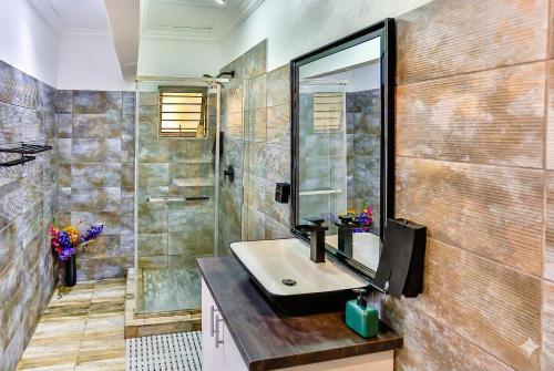 un bagno con lavandino, doccia e specchio di Van Gogh a Ballito