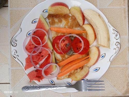 a plate of food with fruit and vegetables on a table at Longonot View Camp and Accommodation, Naivasha in Naivasha
