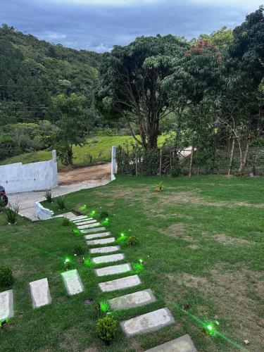een stenen pad in een veld met groen gras bij Gamboa House in Garopaba