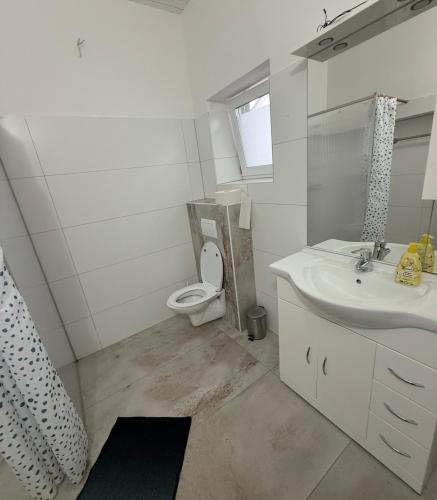 une salle de bains blanche avec toilettes et lavabo dans l'établissement Luxus Apartment - Toskana Gasthaus, à Schwanenstadt