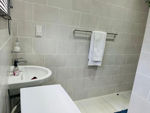 a bathroom with a white sink and a toilet at Travellers paradise in Palatswe