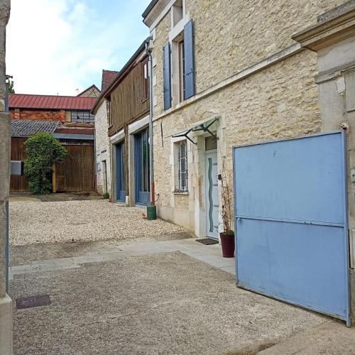 a large blue garage door on the side of a building at Mon Jardin Secret in Maligny