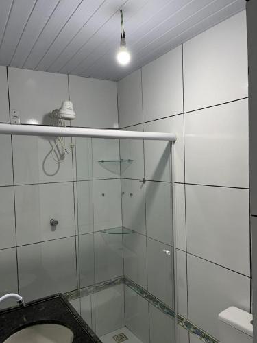 a bathroom with a glass shower and a toilet at pousada palmeiras bhs in Barreirinhas