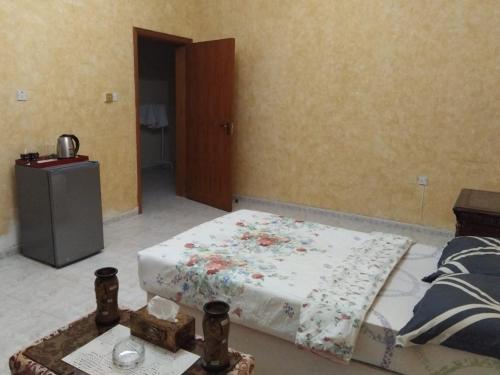 a bedroom with a bed with a flowered blanket on it at DIAMANTE Al Ain - 10 in Al Ain