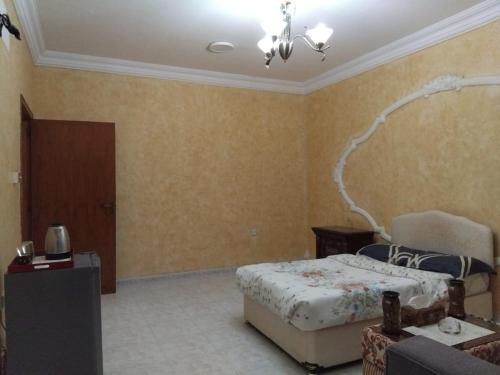 a bedroom with a bed and a chair in it at DIAMANTE Al Ain - 10 in Al Ain