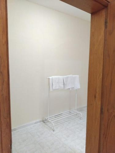 a white towel hanging on a towel rack in a room at DIAMANTE Al Ain - 10 in Al Ain