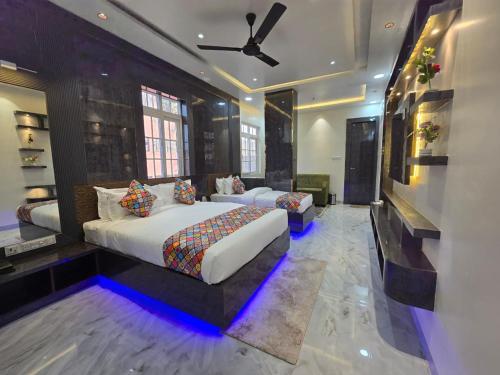 a bedroom with two beds and a ceiling fan at HOTEL REAL Inn in Muzaffarpur