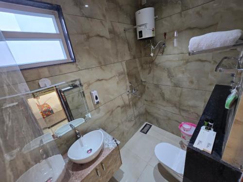 a bathroom with a sink and a toilet and a mirror at HOTEL REAL Inn in Muzaffarpur
