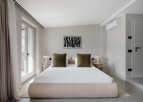 a bedroom with a large white bed and a window at Maison MUSA at Ca' Bela in Sala Comacina