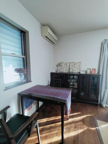 a living room with a table and a window at Tsurumi Green Base 2LDK in Osaka