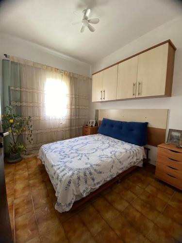 a bedroom with a bed and a ceiling fan at Casa com piscina em Peruíbe in Peruíbe