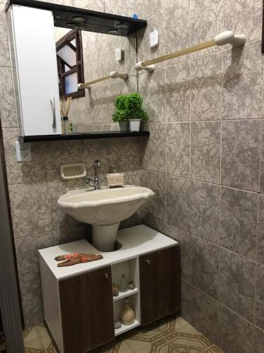 a bathroom with a sink and a counter with a sink at Casa com piscina em Peruíbe in Peruíbe