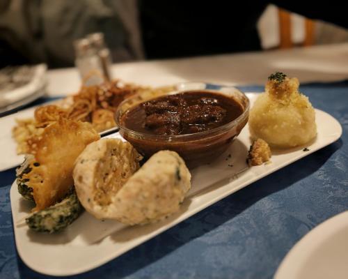 een bord met eten met vlees en groenten op een tafel bij Genusshotel Rhönblick in Ostheim
