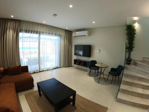 een woonkamer met een bank en een tafel bij The Beach House by JS in Muscat