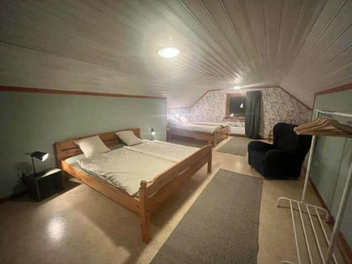 a bedroom with a bed and a chair in a room at NOR118-Junosuando-Keraentoejaervi-81 in Junosuando