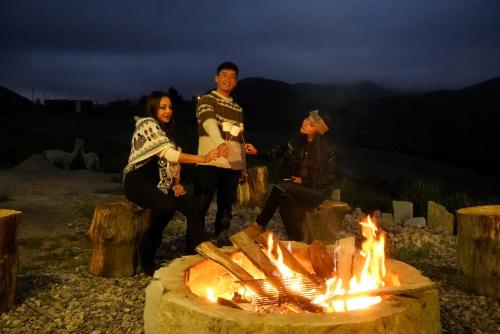 Un gruppo di persone intorno al fuoco di Solarium Cabaña a Riobamba