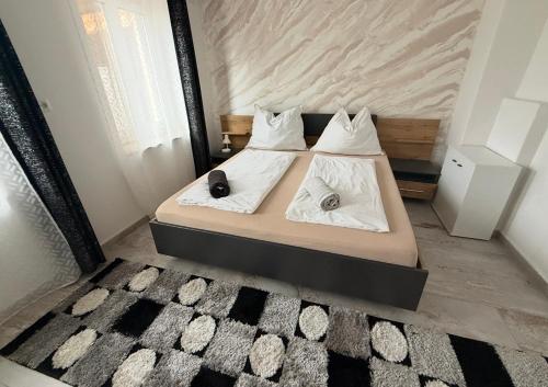 une chambre avec un lit avec des draps blancs et des oreillers dans l'établissement Luxus Apartment - Toskana Gasthaus, à Schwanenstadt