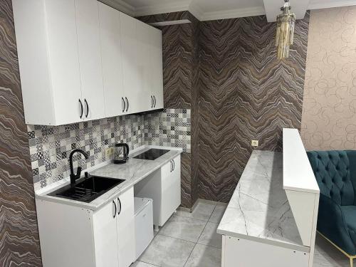 a kitchen with white cabinets and a sink at Hotel Horizont! in Batumi