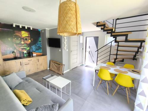 a living room with a couch and a table and yellow chairs at Domki całoroczne Morzemoze in Jastrzębia Góra
