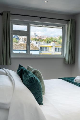 a bedroom with a bed with a large window at Mayflower Penthouse in Dartmouth