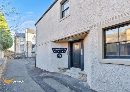 a building with a sign on the side of it at Comfortable 2 Bed Airdrie Flat w Private Parking in Airdrie