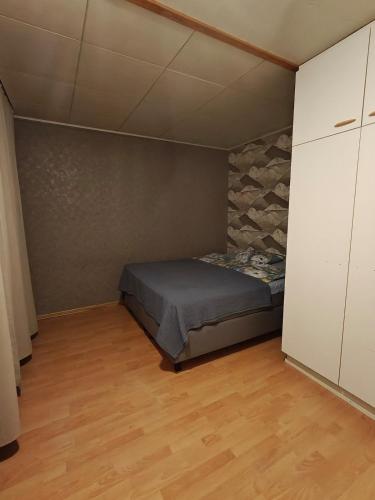 een kleine slaapkamer met een bed en een stenen muur bij Simple Cozy House in Raahe