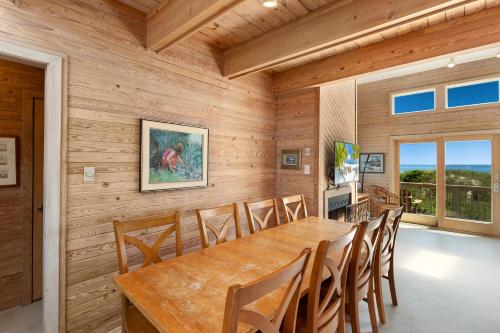 a dining room with a large wooden table and chairs at 1222 - Asher in Corolla